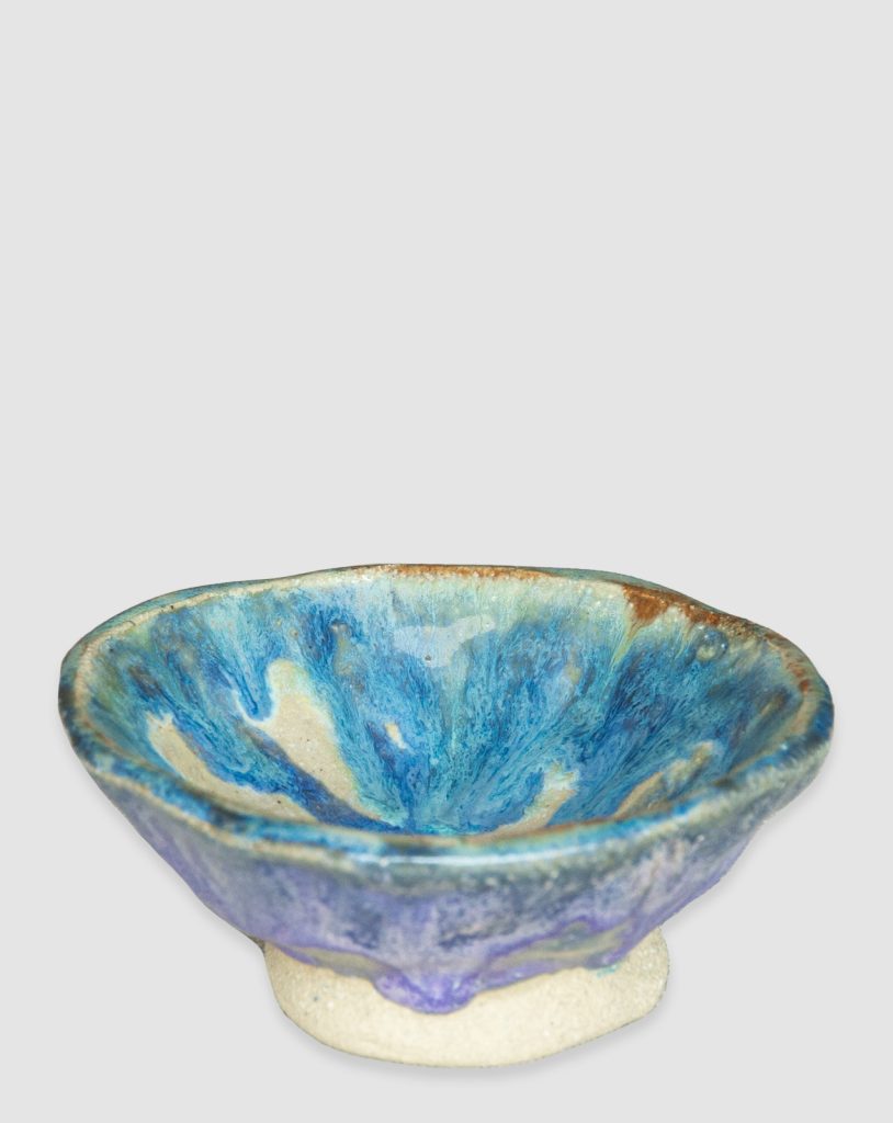 Australian-made ceramic bowl by Kattu, featuring a predominantly white glaze with a striking blue design reminiscent of ocean waves.